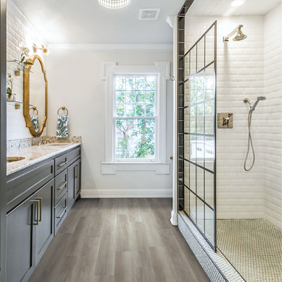 luxury vinyl flooring in bathroom with walk in shower and vanity.