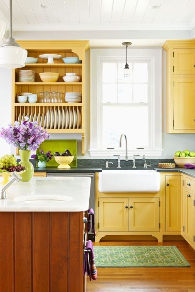 Pale yellow kitchen cabinets in old farmhouse kitchen with open shelving